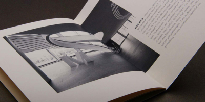 Perspektivische Ansicht einer Magazinseite. Eine Schwarz-Weiß-Fotografie zeigt eine moderne, fast abstrakte Architektur-Skulptur in einer hellen Halle. Der Begleittext rechts thematisiert die Architekturtheorie und Leitsätze wie ‚Form follows function‘.