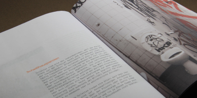 Redaktionelles Layout zum Thema Toiletten-Graffiti. Die rechte Seite zeigt eine großformatige, angeschnittene Fotografie einer beschmierten Kabine. Die linke Seite enthält einen einspaltigen Fließtext unter der orangefarbenen Überschrift „Scheißhausparolen“.